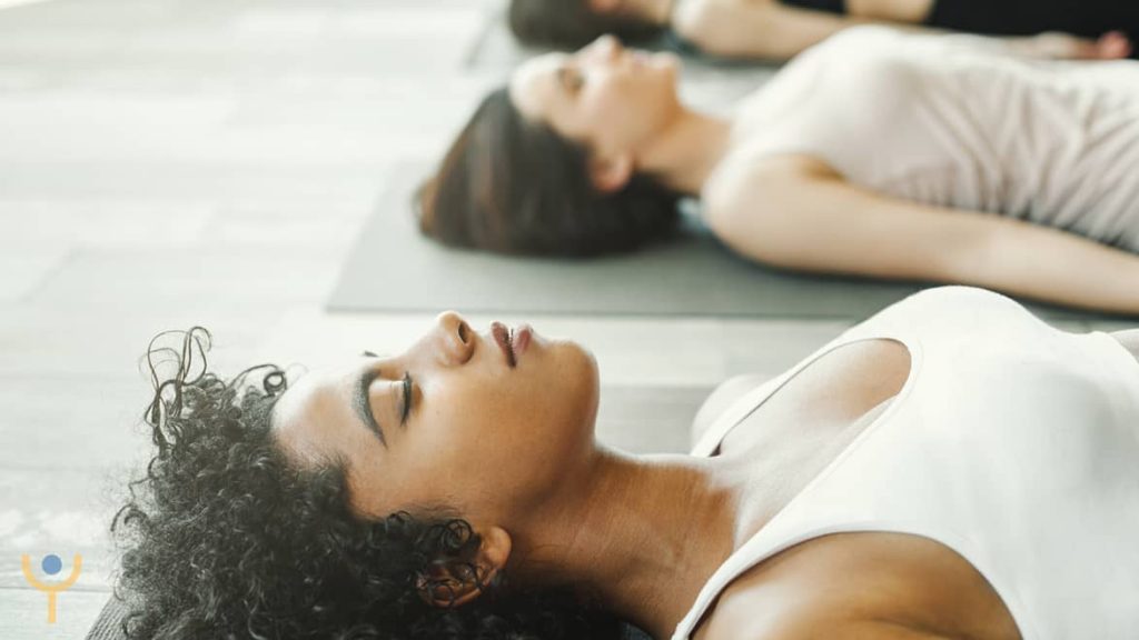 Mujer yogui acostada en Savasana